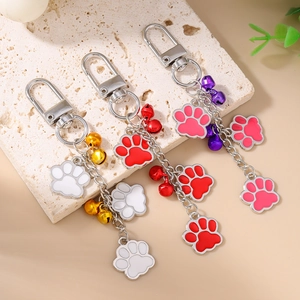 Detail view of paw print keychains with colorful enamel charms and decorative bells