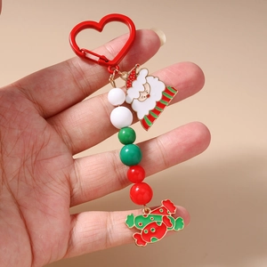 Handheld view of Christmas keychain with red heart carabiner and Santa bead charms