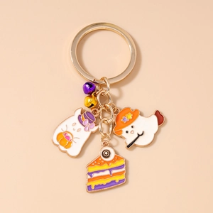 Detail of Halloween enamel keychains with ghosts, pumpkins, and a colorful cake slice