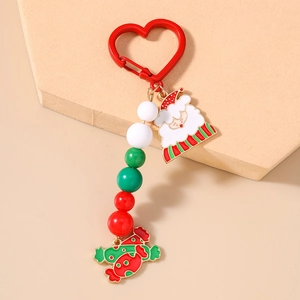 Detail of Christmas beaded keychain with Santa Claus and candy enamel charms on beige stand