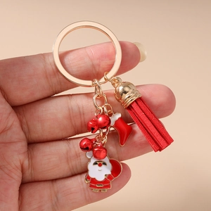 Detail view of Santa Claus and stocking charms with red tassels on gold metal keychain