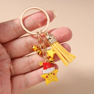 Close-up of a Christmas keychain with yellow star, leather tassel and golden bells