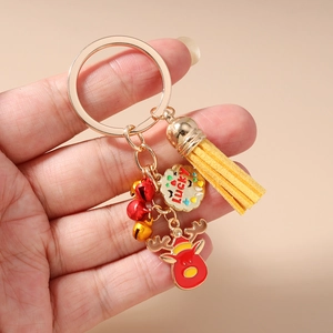 Close-up of a festive Christmas reindeer keychain with gold bells and yellow tassel detail