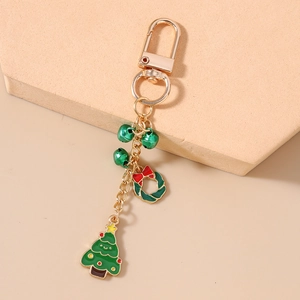 Porte-clés de Noël avec cloches vertes, couronne et sapin sur un anneau doré