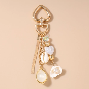 Detail of ocean-themed keychain with golden heart ring, pearls, and shell charms
