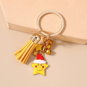 Detailed view of yellow enamel star charm with Christmas hat, fringe tassel and gold bells