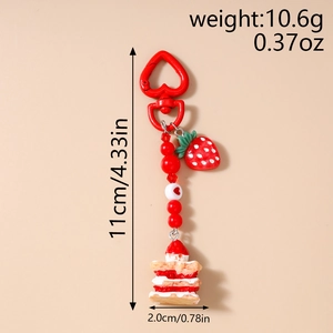 Detailed view of red strawberry cake keychain with size specs and heart beads
