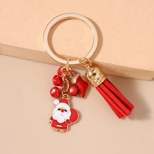 Detail of Christmas keychain with Santa charm, red tassel, bells and gold plating