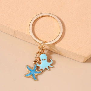 Detail of a golden keychain with a navy blue starfish and light blue octopus charm