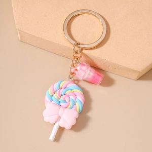 Detail of colorful rainbow lollipop and milk tea cup keychain charms on gold chain