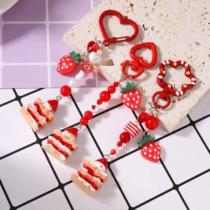 Three strawberry cream cake keychains with red heart beads and heart-shaped metal hooks