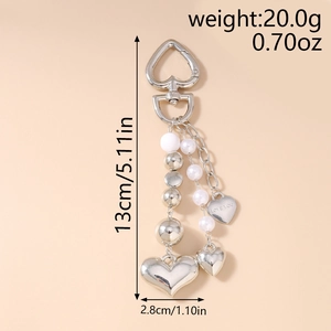 Détail du porte-clés coeur argenté avec perles et gravure LOVE YOU sur une vue à plat