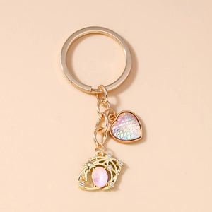 Detail of golden heart keychain with pink fish scale texture and galaxy star gem pendant
