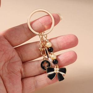 Détail du porte-clés à talons hauts avec perles noir et blanc et pendentif nœud