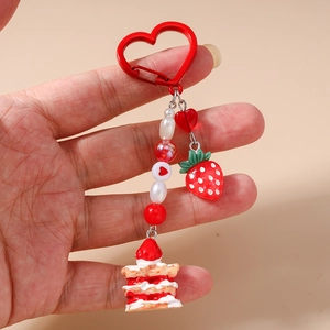 Detail of strawberry cake keychain with red heart buckle and pearl beads for bags