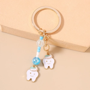 Close-up of cute cartoon tooth keychains with colorful beads and gold metal ring