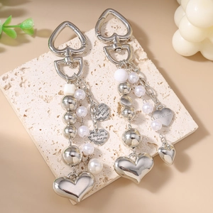 Porte-clés cœur argenté chic avec perles et glands sur support en pierre naturelle
