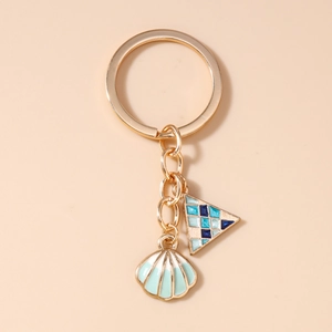 Close-up of golden keychain with blue geometric and mint green shell oil drip charms