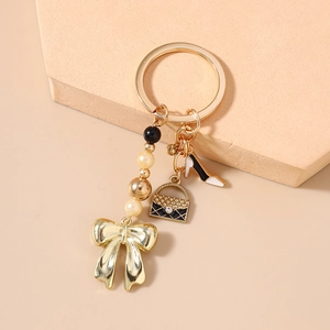 Détail d'un porte-clés doré avec perles, pendentifs sac à main et chaussure à talons