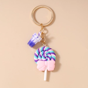 Detail of colorful swirl lollipop and purple drink cup charms on a gold keychain
