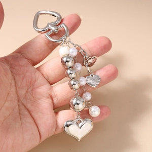 Détail du porte-clés en forme de cœur avec perles et pendentif gravé love you