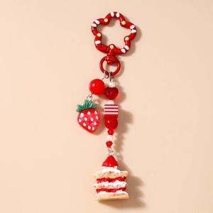 Detailed view of red heart beads with strawberry pendant and mini cake charm on keychain