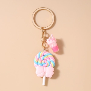 Detail of colorful spiral lollipop keychain with a pink bow and miniature milkcup charm