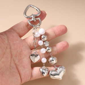 Détail du porte-clés cœur argenté avec perles blanches et pendentif gravé Love You