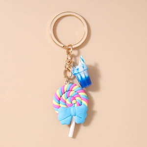 Detail of colorful spiral lollipop and blue drink cup charms on a golden keychain