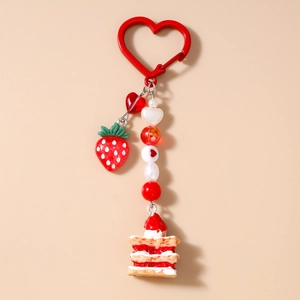 Close-up of heart clasp with strawberry pendant and beaded chain cake charm