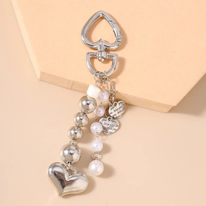 Vue détaillée d'un porte-clés cœur argenté avec perles et gravure love you