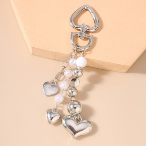 Détail du porte-clés cœur avec perles blanches et gravure Love You en métal argenté