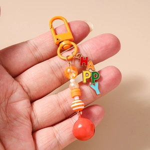 Detail of colorful beaded keychain with HAPPY charm and orange carabiner held by hand