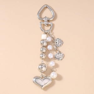 Détail d'un porte-clés coeur argenté avec perles fantaisie et breloques gravées Love You