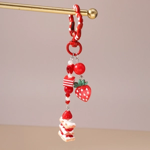 Detail of strawberry cake keychain with red heart beads and cute dessert pendants