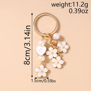 Detail of keychain with white enamel cherry blossoms, pearls and dimensions shown