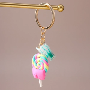 Detail view of colorful swirl lollipop and mini drink cup pendants on gold keychain
