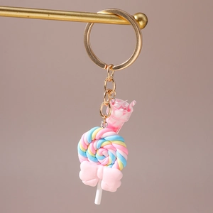 Close-up of rainbow spiral lollipop keychain with pink bow and ice cream charm
