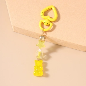 Dettaglio del portachiavi a forma di orsetto giallo con chiusura a cuore e stelle