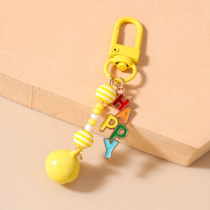 Detailed view of yellow bell and colorful HAPPY letter charms on beaded keychain