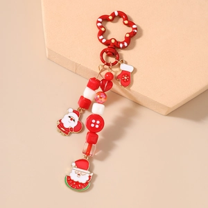 Detailed view of Christmas keychain with red beads, Santa and heart charms on a stand