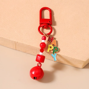 Close-up of colorful beaded HAPPY keychain with red bell and enamel letter charms