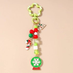 Close-up of Christmas keychain with Noel plate, candy cane, and Xmas snow globe charms