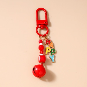 Detail of red beaded keychain with HAPPY letter charms and a small metal bell pendant
