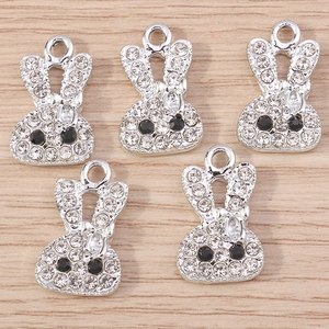 Lot de cinq breloques lapins en strass pour bijoux DIY sur fond de bois naturel clair