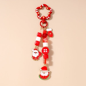 Detailed close-up of a red Christmas keychain with beaded charms and Santa motifs