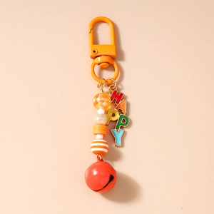 Detail of beaded HAPPY keychain with orange lobster clasp, red bell, and colorful beads