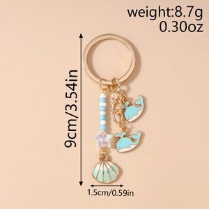Detail of whale and shell charms keychain showing weight and size specifications