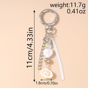 Detail view of silver keychain with rhinestone chain, snake chain and white shell pendant