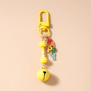 Detail of yellow beaded keychain with HAPPY rainbow letter charm and vibrant metal bell